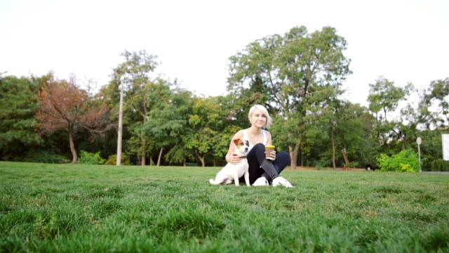 Mujer-joven-con-poco-lindo-jack-terrier-russel-en-el-Parque