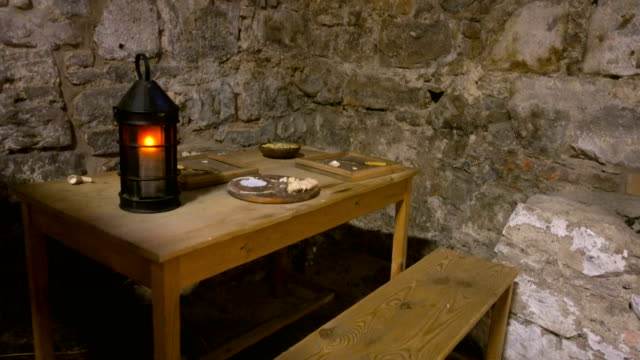 Holztisch-in-einem-Steinhaus-mit-einer-Lampe-und-Essen