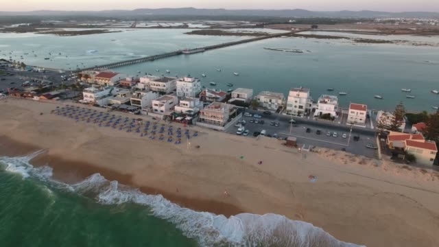 Volando-sobre-la-playa-de-Faro-(Praia-de-Faro)-durante-la-puesta-del-sol,-Algarve,-Portugal