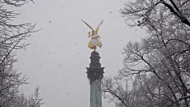The-Angel-of-Peace-on-the-top-of-Friedensengel-monument-in-Munich,-Germany-during-the-snow-srorm