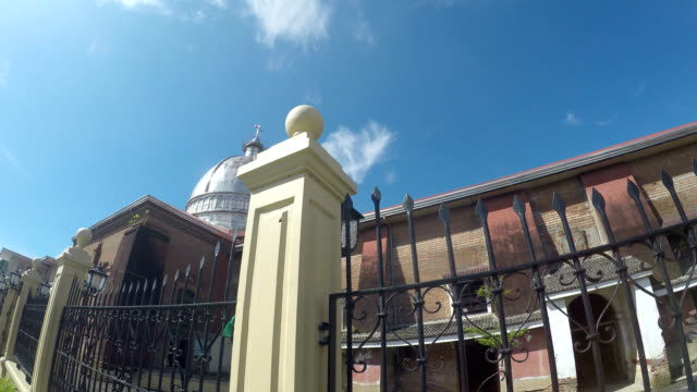 Colonial-16th-century-Spanish-built-of-Saint-Paul-the-First-Hermit-Cathedral-also-known-as-San-Pablo-Cathedral,-showing-her-surrounding-iron-fence-at-the-east-side-nave-brick-walls.-tracking-shot