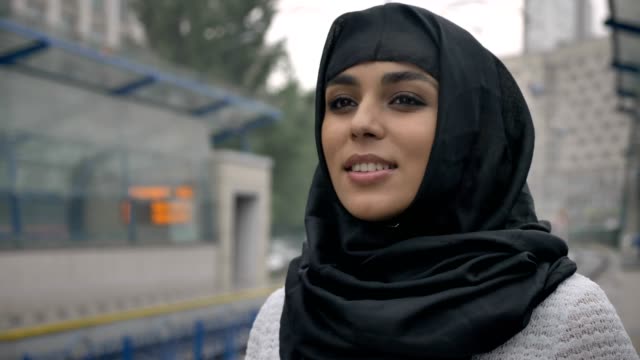 Joven-mujer-musulmana-soñando-en-hiyab-está-esperando-tren,-lloviendo,-concepto-de-religión,-concepto-urbano.-concepto-de-tiempo