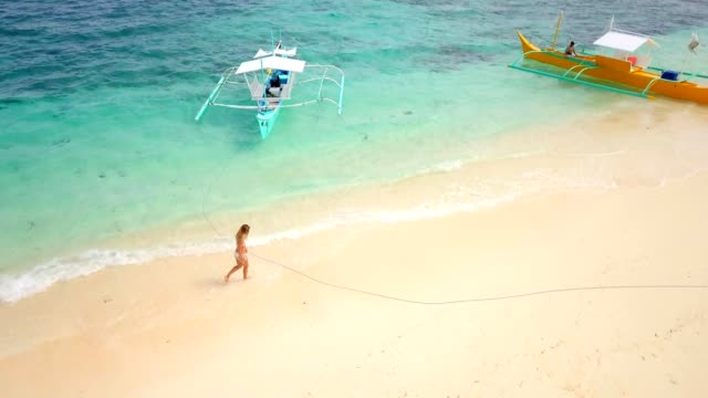 Luftbild-Drohne-schoss-der-jungen-Frau-zu-Fuß-auf-idyllischen-tropischen-Strand