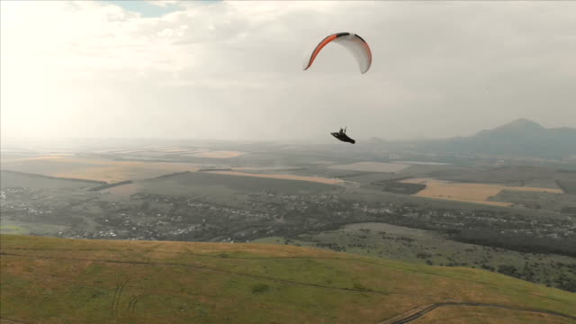 Athlete-paraglider-flies-on-his-paraglider-next-to-the-swallows.-Follow-up-shooting-from-the-drone