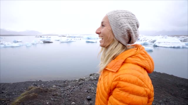 Junge-Frau-touristischen-weiblich-zu-Fuß-auf-durch-die-Gletscherlagune-Jökulsárlón-Beach