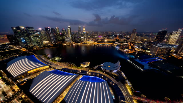 Lapso-de-tiempo-de-show-de-luces-en-el-centro-de-la-ciudad-de-Singapur-en-Marina-Bay-area.-Edificios-barrio-y-rascacielos-financieros.-Vista-aérea-en-la-noche.