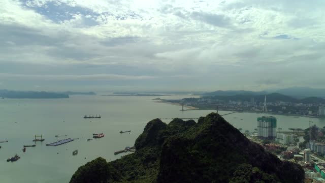 4k-Aerial-view-over-city-and-park-with-Bai-Tho-karst-mountain-Ha-long-bay.-Halong-City.