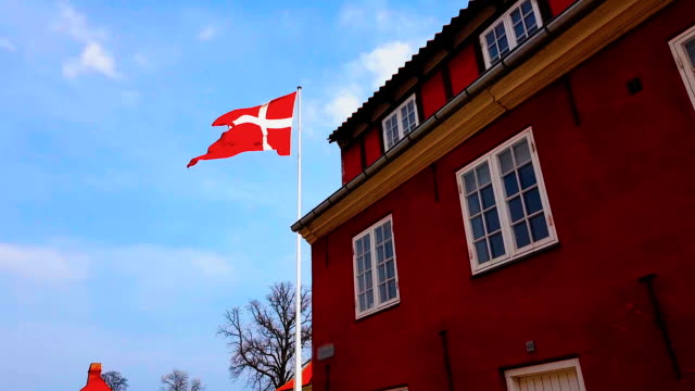 National-flag-of-Denmark-on-top-embassy-building,-diplomatic-mission,-consulate