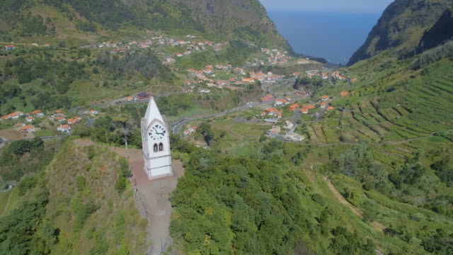 Hermosa-torre-del-reloj-viejo-en-una-colina-en-Madeira-con-el-valle-en-la-distancia
