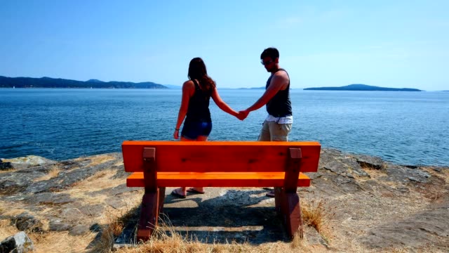 Woman-leads-Man-to-Park-Bench-overlooking-Water-View