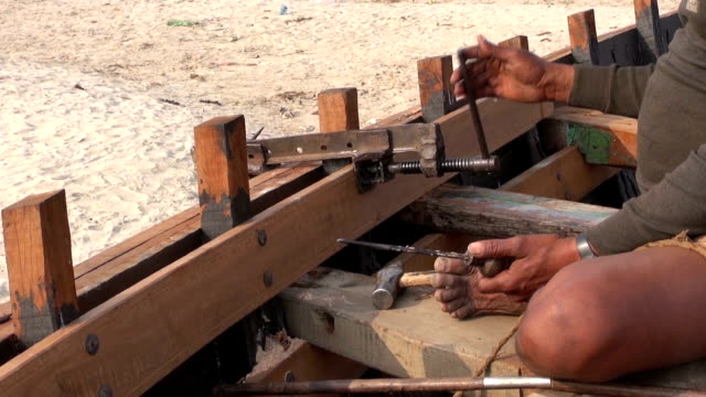 master-con-primitive-herramientas-de-construcción-en-embarcación-cerca-del-río-Ganges,-varanasí