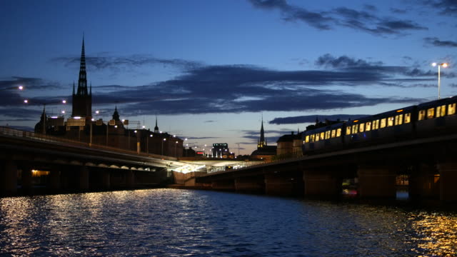 Puentes-en-la-ciudad-de-Estocolmo-en-la-noche.-Trenes-del-metro-pasando-por-puente-del-ferrocarril