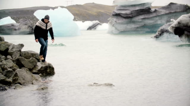 Hübscher-Jüngling-am-Ufer-in-Jokulsalon-Eis-Lagune-stehen-und-blickte-auf-die-Gletscher-in-Island