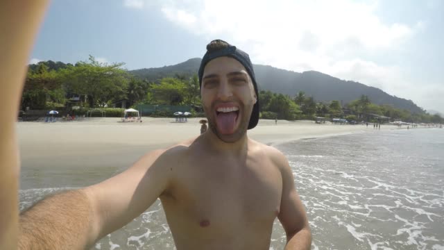 Young-Brazilian-Guy-taking-a-selfie-on-the-beach