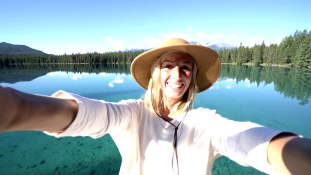 Mujer-selfie-pov-por-lago-alpino-en-las-montañas-Rocosas-canadienses