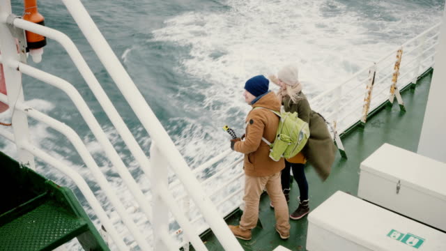 Draufsicht-des-jungen-Paares-stehen-an-Bord-des-Schiffes.-Mann-und-Frau-mit-Action-Kamera-genießen-den-Blick-auf-Meer