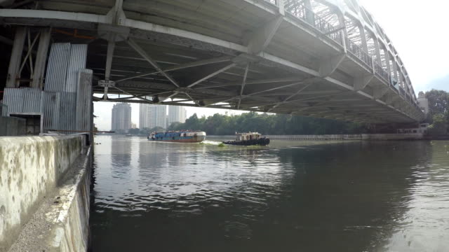 Schlepper-Boot-schleppen-Lastkähne-am-Pasig-River-in-Richtung-lange-Span-Eisenbrücke.