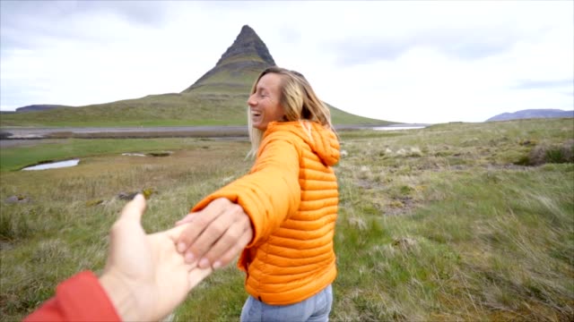 Follow-me-to-nature,-girlfriend-leading-man-to-Kirkjufell-mountain