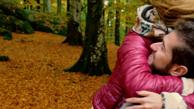 young-woman-running-and-hugging-his-boyfriend-in-fall-park