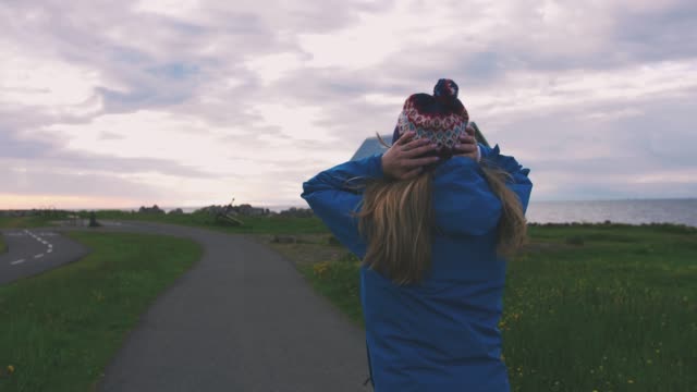 Vista-trasera-del-turista-mujer-caminando-en-Islandia