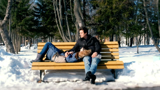 Hombre-y-una-mujer-estar-juntos-en-un-banco-en-la-ciudad-de-winter-Park.-Día-soleado-de-invierno.