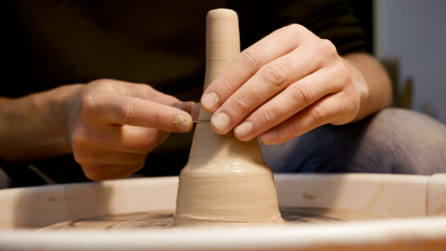 Manos-del-hombre-haciendo-cerámica-de-barro-en-el-torno-de-alfarero