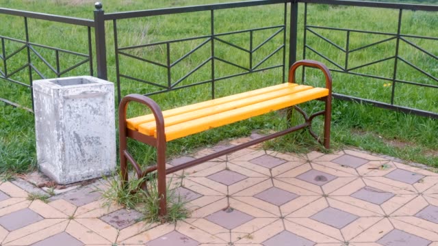 Bench-by-the-fence-in-park.-Near-the-trash.