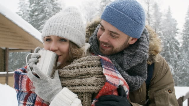 Beautiful-Couple-Hugging-and-Drinking-Tea-in-Winter-Forest