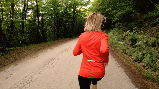 Running-girl.-Blonde-girl-doing-outdoor-sports-in-the-summer-forest.-Rear-view-slow-motion-wide-angle-Close-up