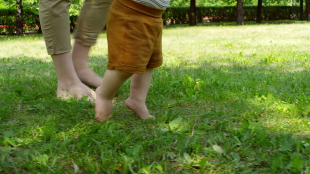 Mujer-y-bebé-caminar-descalzo-sobre-la-hierba