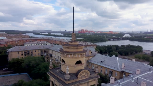 Drone-flight-near-the-old-style-tower-with-factory-on-the-background