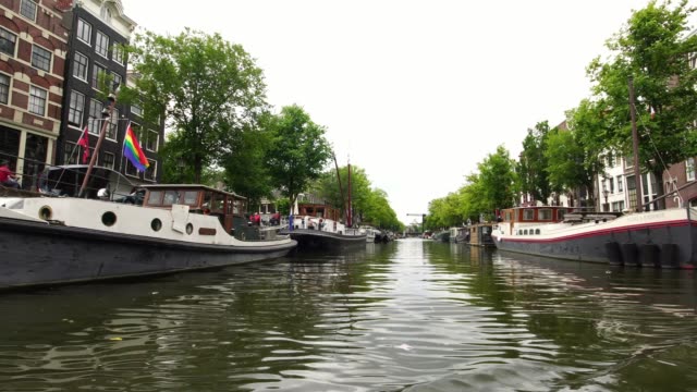 pasar-el-barco-con-bandera-del-arco-iris-en-Amsterdam,-Holanda-Europa