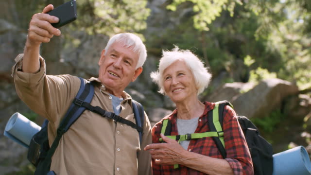 Glücklich-Senioren-nehmen-Selfie-im-Wald