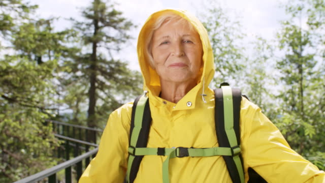 Senior-mujer-posando-para-la-cámara-en-el-bosque-de-la-montaña