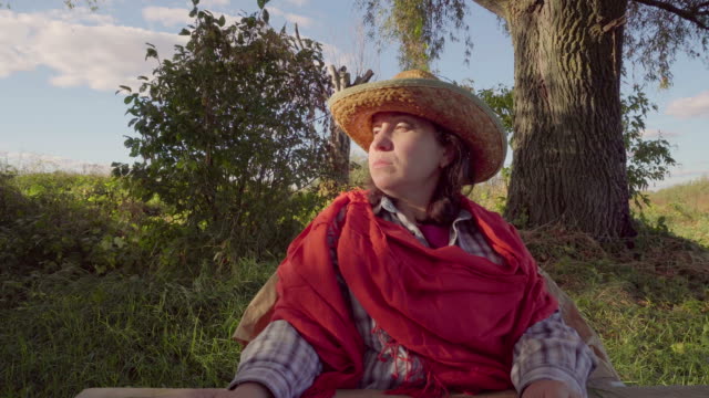 Frau-in-Stroh-Hut-und-Schal-auf-Natur-Hintergrund