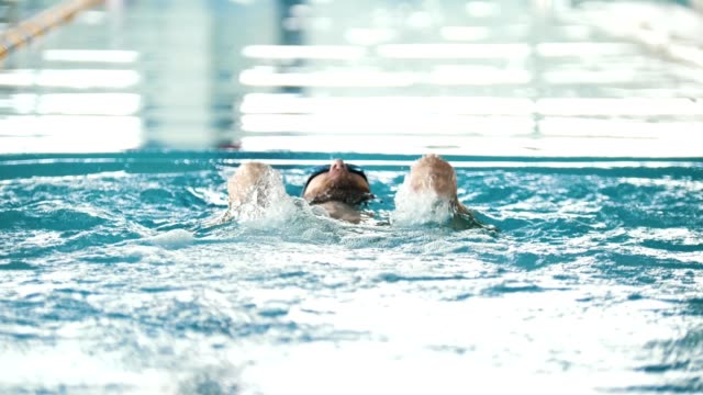 Behinderte-Mensch-Schwimmen-auf-dem-Rücken-in-einem-Schwimmbad.-Der-Schmetterling-Strich.-Slow-motion