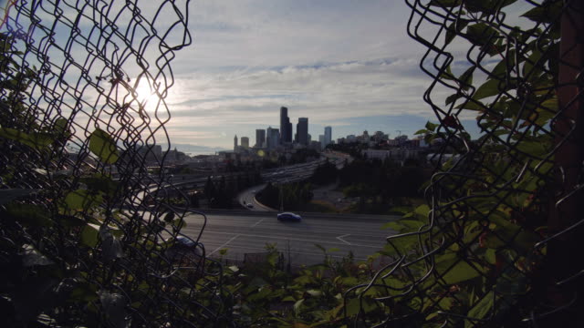 Vista-del-Skyline-de-ciudad-a-través-del-agujero-en-la-cerca-de-cadena
