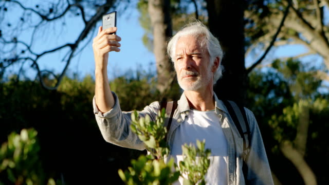 Senior-hombre-tomando-selfie-con-teléfono-móvil-en-el-campo-4k