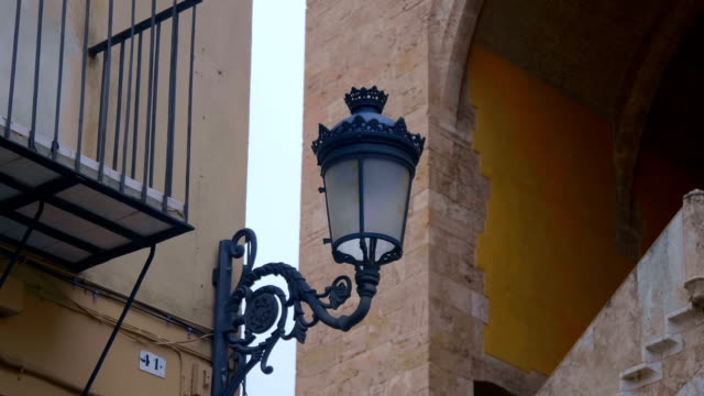 Vintage-Straßenlaternen-an-den-Wänden-der-spanischen-Häuser