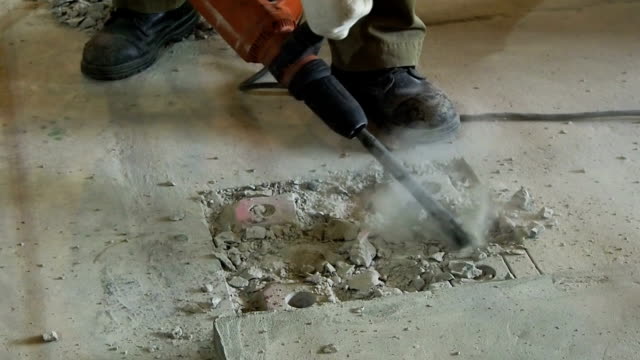 Industrial-Arbeitnehmer-mit-drill-konkrete-Electric-plugger-hammer-auf-Baustelle.