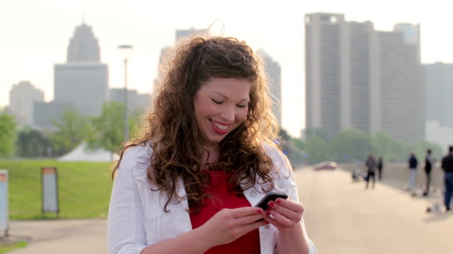 Brunette-mujer-utilizando-un-teléfono-inteligente-en-Detroit