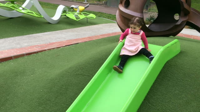Kleines-Mädchen-auf-eine-Wasserrutsche-Rutschen-auf-dem-Spielplatz