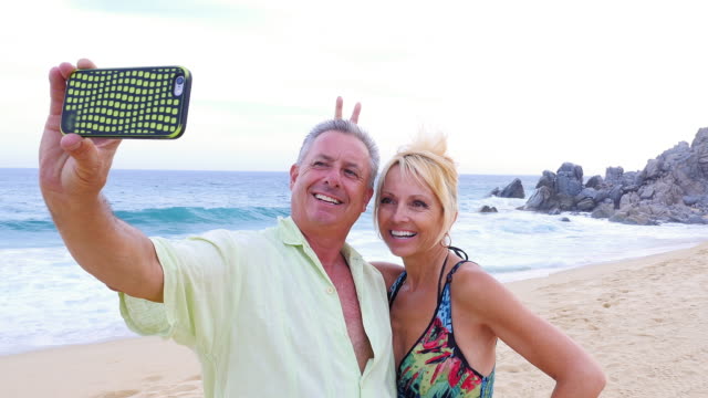 Una-Pareja-de-ancianos-divirtiéndose-y-tomando-los-\"-selfies\"--en-la-playa