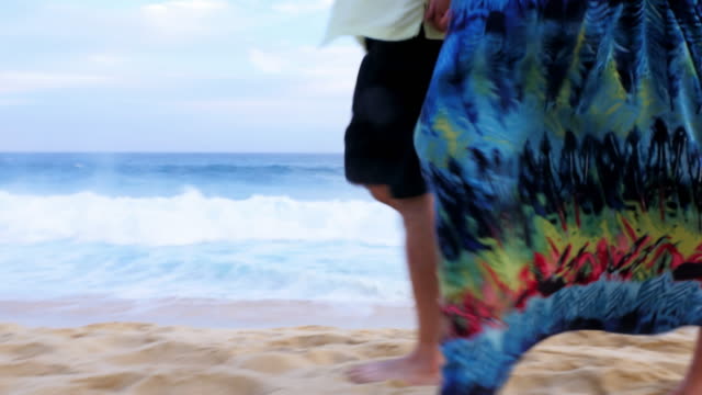 Close-up-of-the-feet-of-an-older-couple-walking-down-the-beach