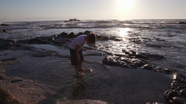 Jóvenes-chico-explorar-roca-piscina-en-la-playa-en-Ciudad-del-Cabo,-Sudáfrica