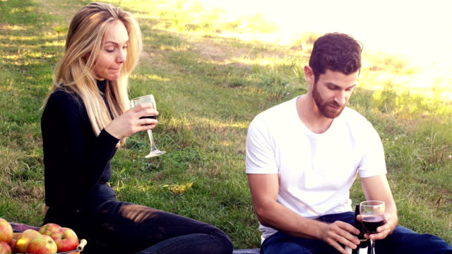 Couple-having-wine-in-orchard