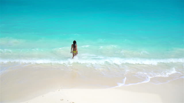 Entzückende-kleine-Mädchen-am-Strand-mit-einer-Menge-Spaß-im-flachen-Wasser