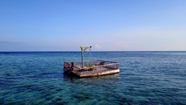 v03834-fliegenden-Drohne-Luftaufnahme-der-Malediven-weißen-Sandstrand-2-Personen-junges-Paar-Mann-Frau-entspannend-auf-sonnigen-tropischen-Inselparadies-mit-Aqua-blau-Himmel-Meer-Wasser-Ozean-4k-schwimmenden-Ponton-Steg-Sonnenbaden-zusammen