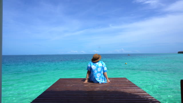 Woman-relax-at-bright-blue-summer-ocean.-Enjoying-sea-breeze-on-vacation-4k