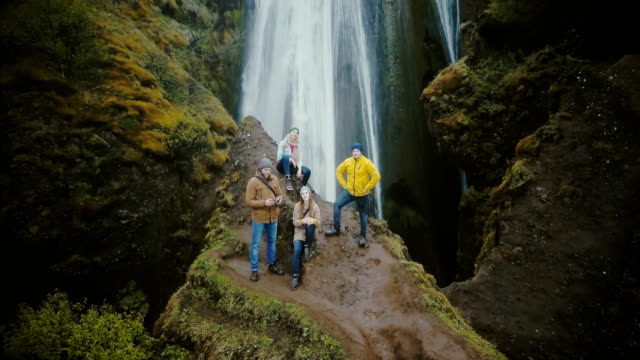 Aerial-view-of-the-tourists-in-Gljufrabui-waterfall-in-Iceland.-Copter-moving-away-from-friends,-selfie-on-drone
